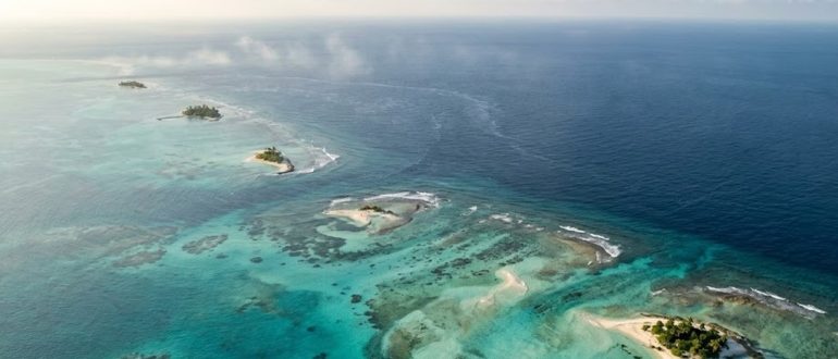 Коралловые рифы и бирюзовая вода тропического моря с высоты
